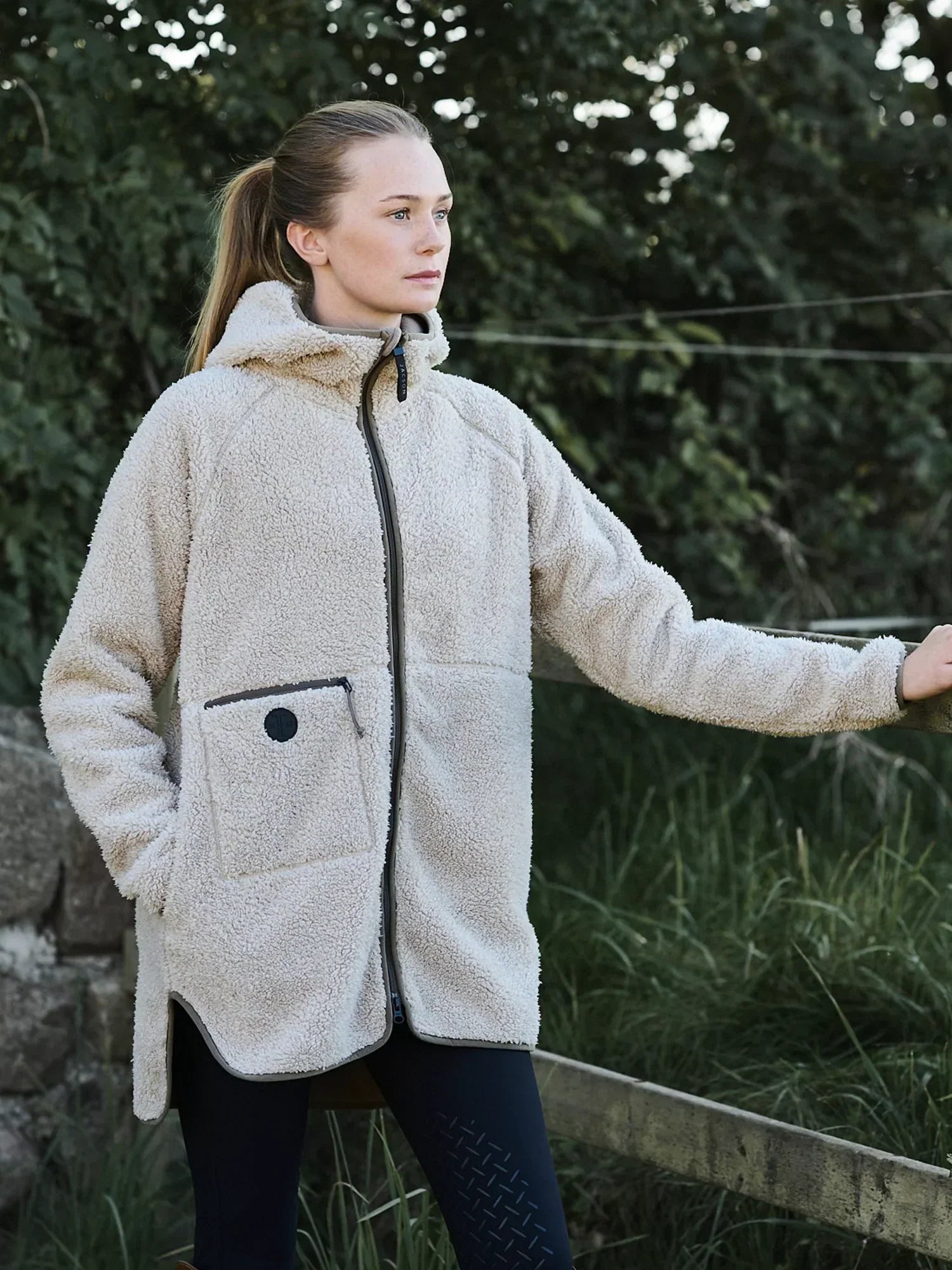 Oversized teddyjacka i mjukt teddyfleece med microfleece-insida, stor huva, tvåvägsdragkedja och praktiska fickor för stil och komfort i stallet.